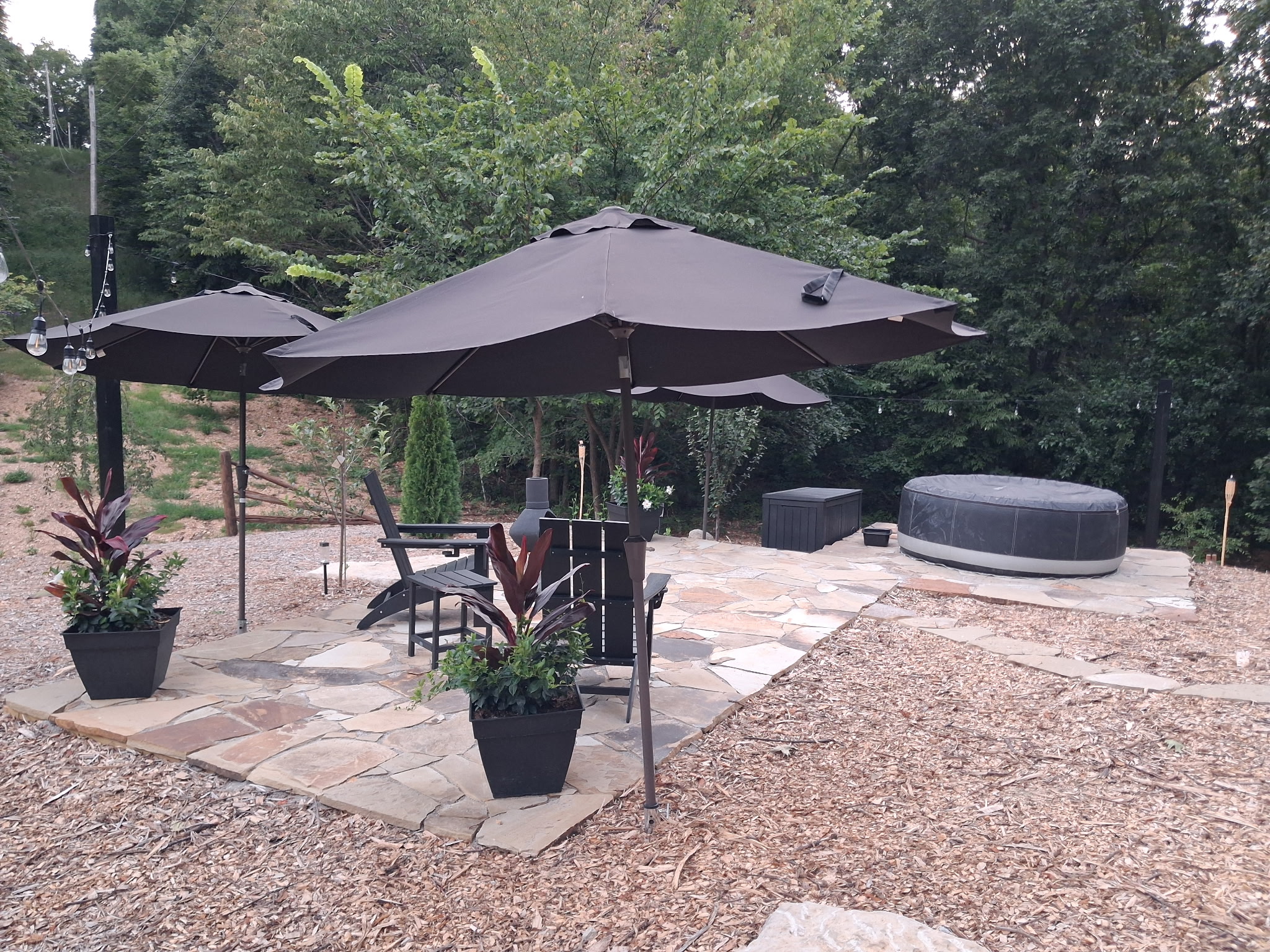Stone patio with seating area and hot tub